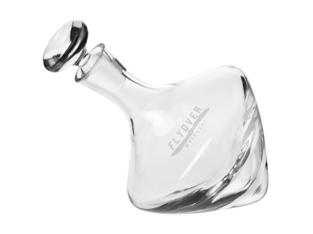 A drink bottle with a unique twisted design, made of clear glass and featuring a round stopper.