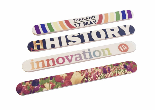 Four colourful nail files with various designs, including floral patterns and text. Each file features unique branding.