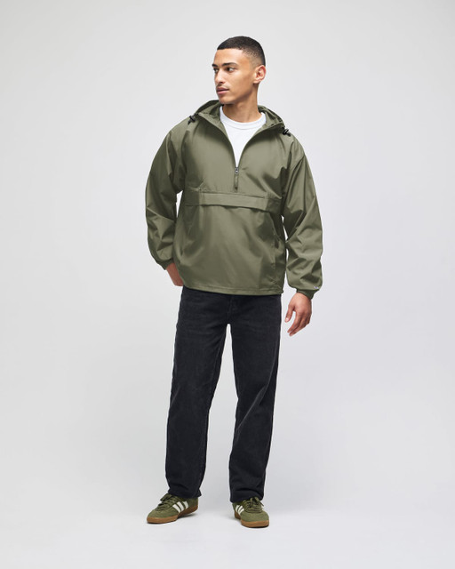 An olive green packable anorak jacket, featuring a hood and half-zip, worn by a model with black pants.