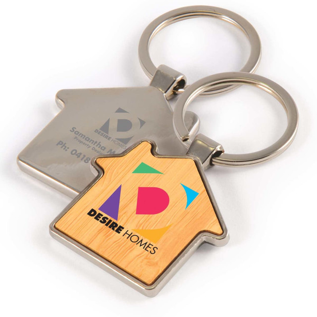 A house-shaped keytag with a bamboo and zinc design featuring a colorful logo and contact information.