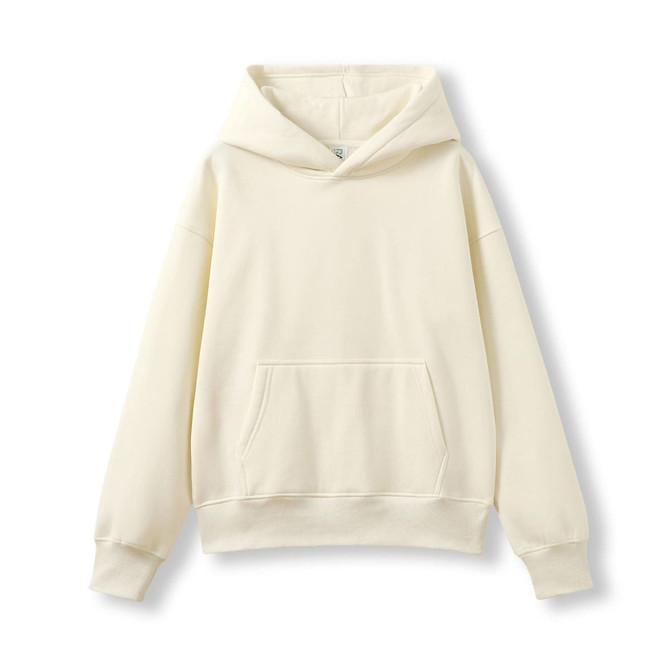 A cream-coloured oversized hoodie with a front pocket and a large hood. It features a logo on the tag.