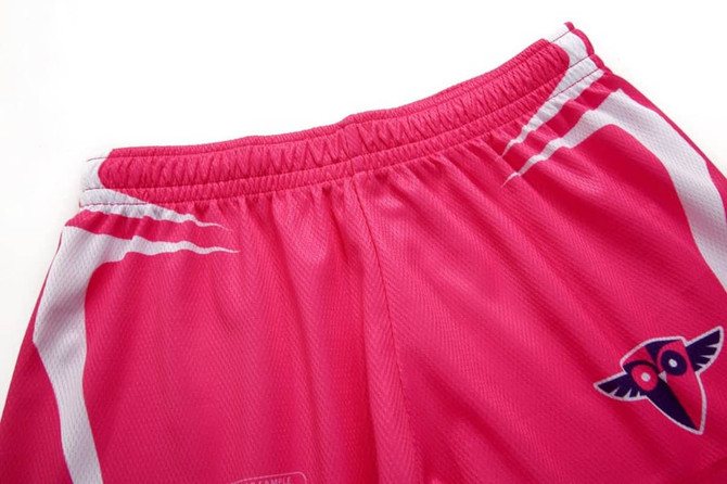 Pink volleyball shorts featuring a white design and a logo on the front.