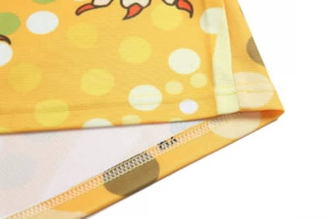 A close-up of a yellow basketball uniform featuring a playful design with circular patterns and a logo.