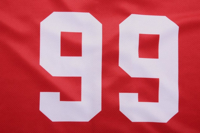 A red baseball full button tee featuring large white numbers '99'. The fabric is breathable and textured.