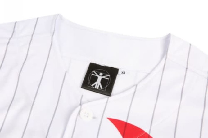 A white baseball uniform featuring vertical stripes and a red accent, with a label and logo on the collar.
