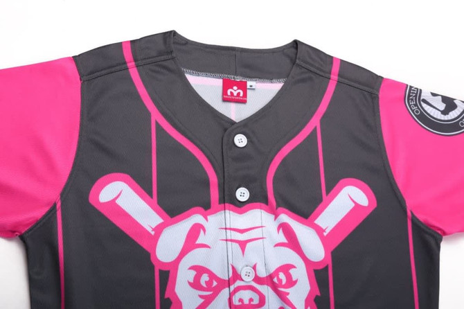 A full button baseball jersey featuring black fabric with bright pink sleeves and a graphic design, including a logo.