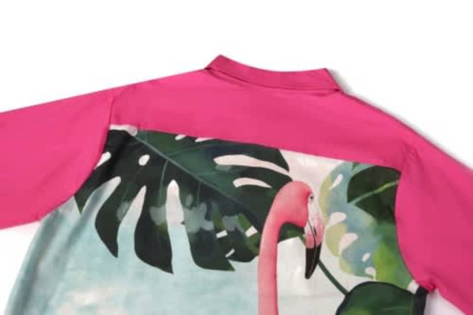 A pink women's beach shirt featuring a large tropical print with a flamingo and green leaves.