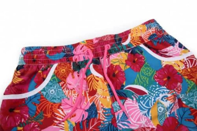 A pair of vibrant shorts featuring a floral pattern in various colours, with a drawstring waist and side pockets.