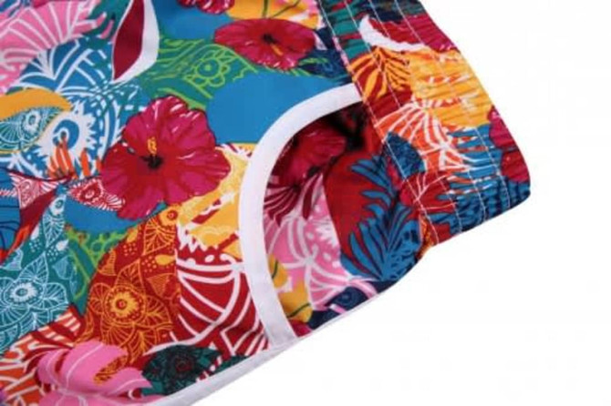 A vibrant beach shirt and shorts set featuring a multicoloured floral pattern and white trim.
