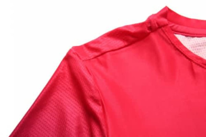 A red sports jersey featuring mesh fabric and a collar, suitable for cycling or team wear.
