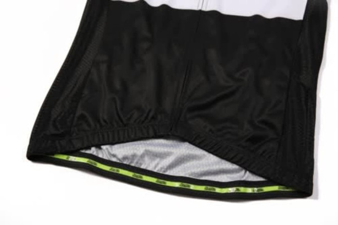 A black cycling jersey featuring a mesh fabric and a lime green interior lining, with an understated logo.