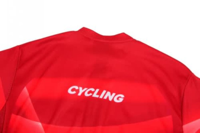 A red cycling uniform jersey featuring a logo on the back. The fabric appears lightweight and breathable.