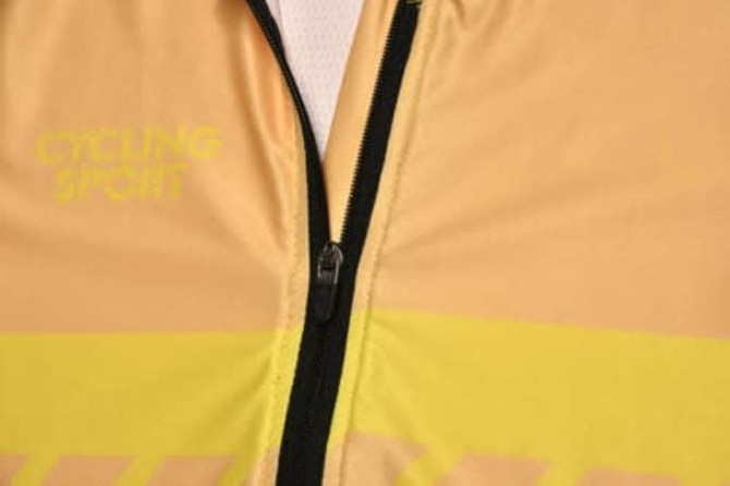 A cycling jersey in yellow and cream with a zip, featuring a logo on the front.