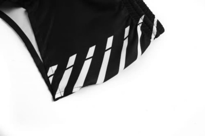 A black sports uniform featuring a striped design in white along the side. It has a logo present.