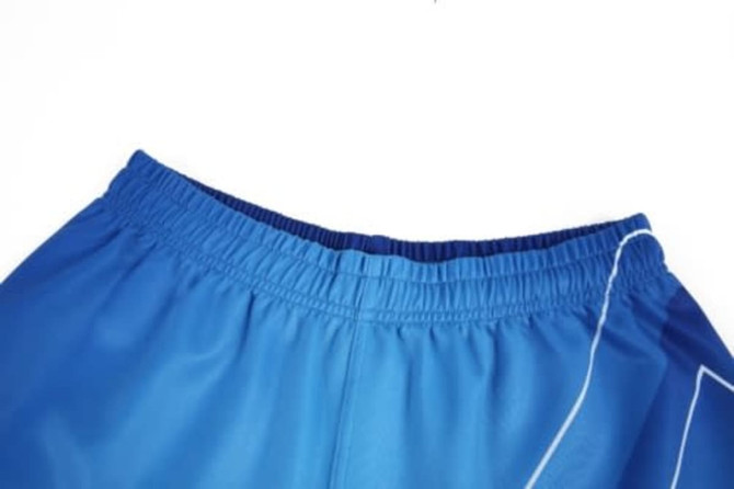 Blue sports shorts with an elastic waistband and white detailing. Features a logo on the side.