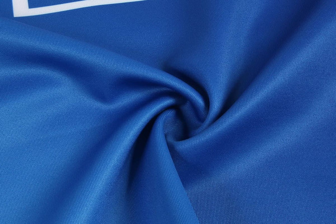 A blue fabric swatch, showcasing smooth texture, possibly from a sports singlet, with a logo present.