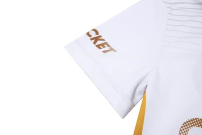 A cricket uniform in white and yellow featuring a logo on the sleeve.