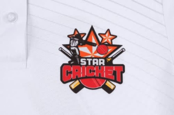 A white cricket uniform featuring a prominent logo with stars, bats, and a ball design in bold colours.