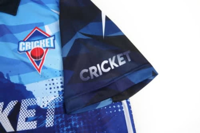 A blue and dark jersey featuring a logo and the word 'CRICKET' on the sleeve.