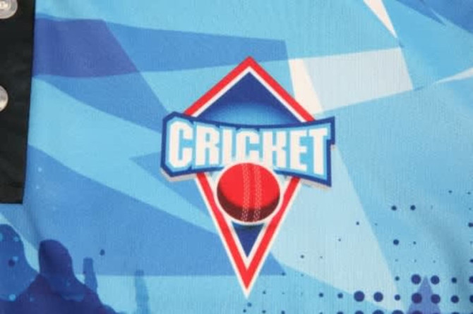 A blue cricket jersey featuring a graphic logo. The design includes abstract patterns and colours.
