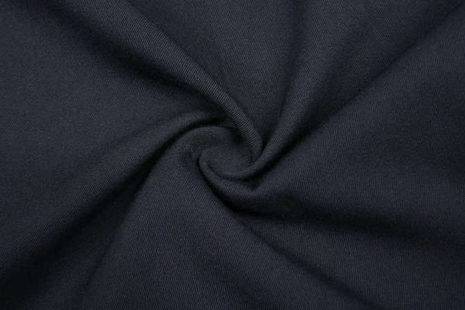 A black fabric with a smooth texture, arranged in a spiral pattern, suitable for trousers or school wear.