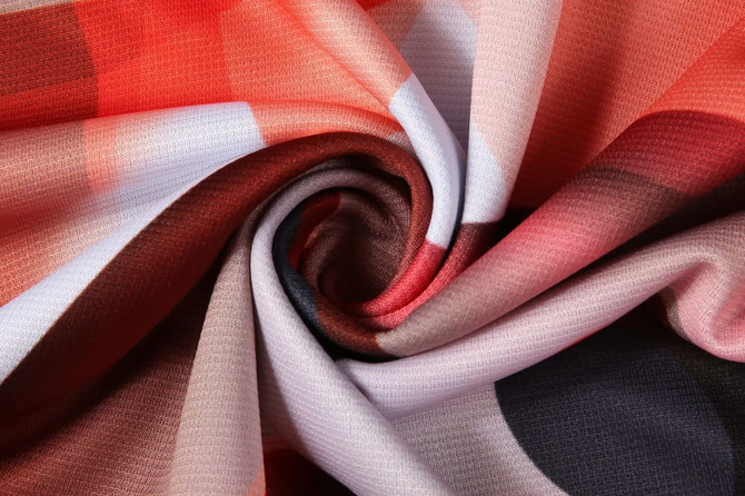 A vibrant, patterned fabric featuring red, pink, brown, and black hues, ideal for sports uniforms.