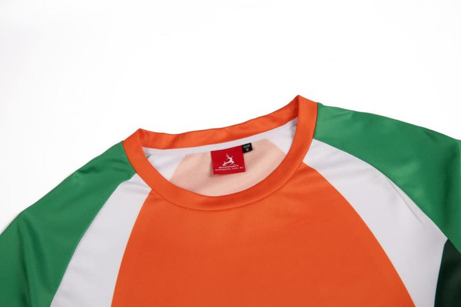 A 3/4 sleeve T-shirt featuring orange, green, and white panels, with a logo on the neckline.