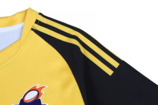 A yellow and black hoodie featuring a logo and striped detailing on the shoulders.