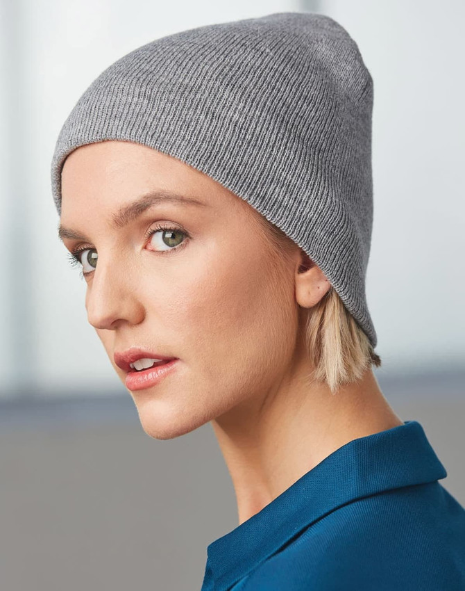 A grey acrylic knitted marl beanie displayed on a model, featuring a fitted design and a subtle texture.