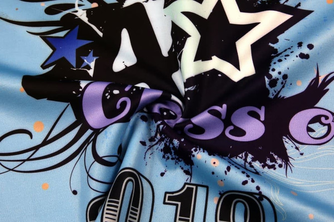 A blue polo featuring colourful stars and designs, with a prominent 'Class of 2010' graphic. It has a branding logo.