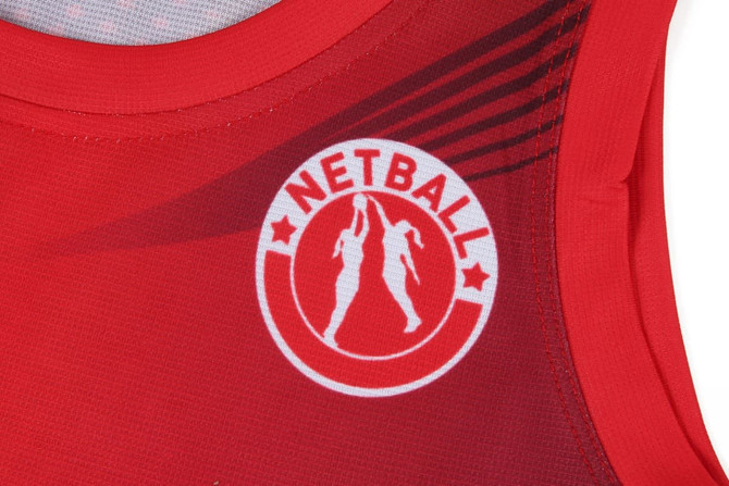 A red netball dress featuring a logo and sleek design, part of sports uniforms for netball.