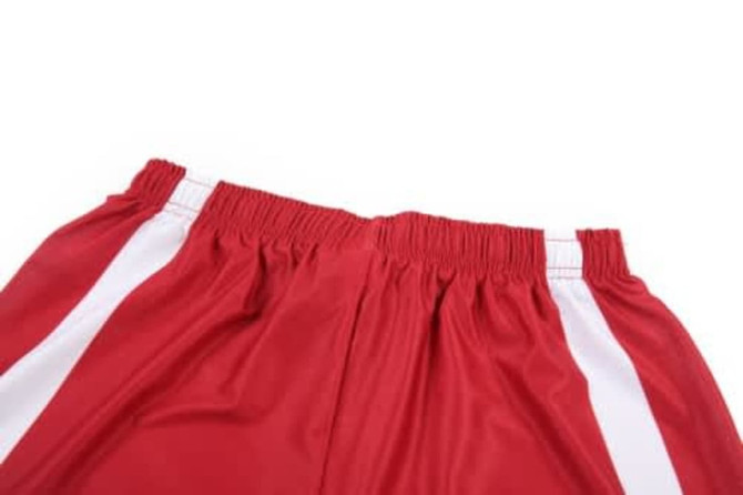 A red soccer uniform featuring elasticated shorts with white stripes. The fabric appears lightweight and breathable.