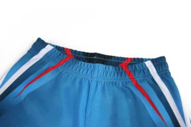 A blue sports jersey featuring white and red stripes, with an elastic waistband and a logo.