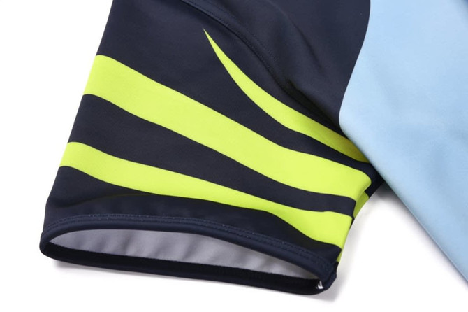 A rugby tee featuring a navy base with bright yellow and light blue accents on the sleeves. It has a branding logo.