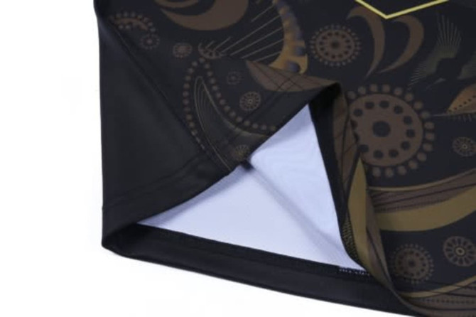 A black and gold Aboriginal rugby top with intricate designs and a textured interior.