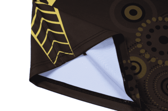 A brown rugby top featuring circular patterns in yellow and black, with a woven detail at the edge and a logo.