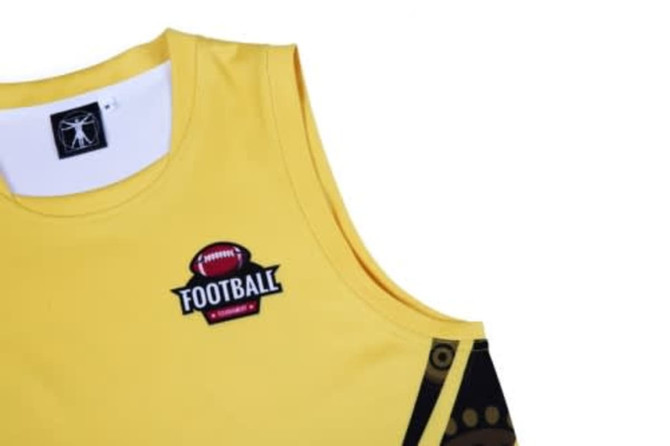 A yellow sports vest with a logo and Aboriginal-inspired design elements.