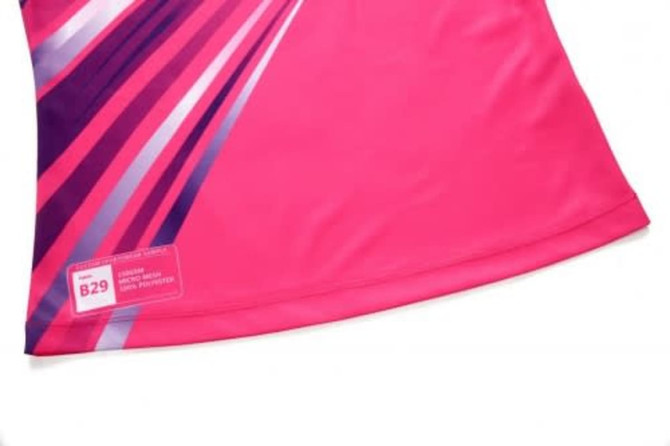 A pink sports uniform featuring bold purple and white design elements, with a small logo on the side.