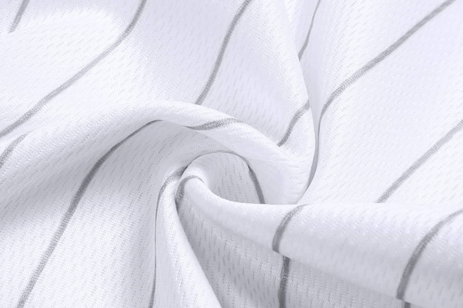 A textured fabric in white with subtle grey stripes, highlighting the material of cropped pants. It features a logo.