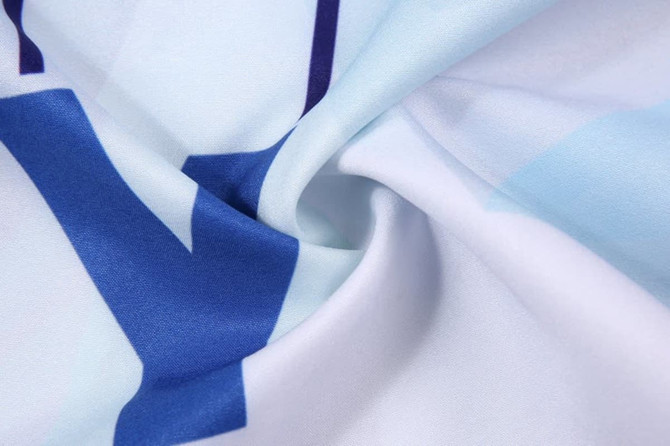 A close-up of patterned fabric featuring shades of blue and white, showcasing the texture and design details.
