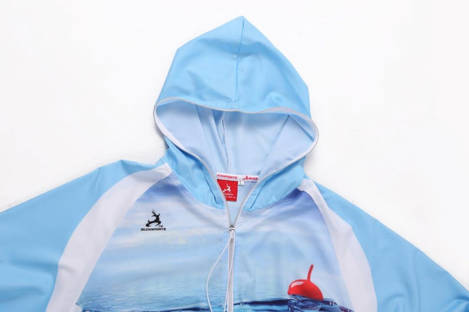 Light blue water-repellent hoodie with a hood and a logo on the front. The fabric features a beach-themed design.