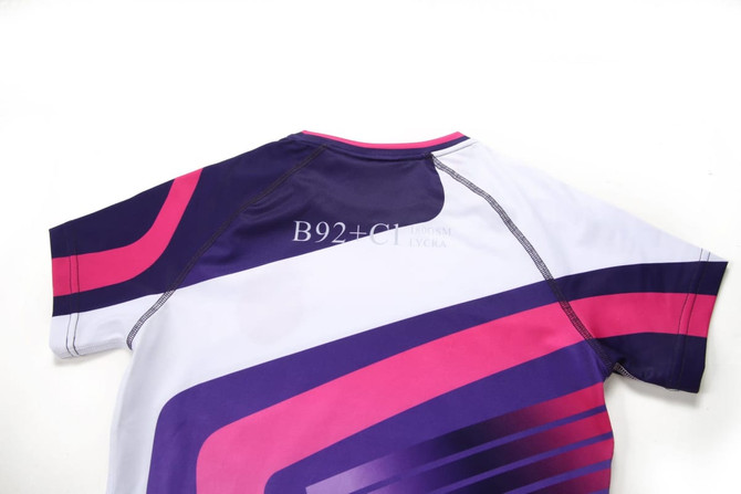 A short-sleeved swimming costume in white, purple, and pink with a sleek design and logo.