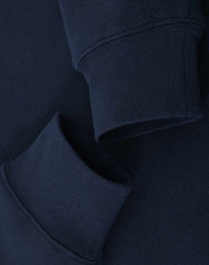 A navy crewneck sweatshirt featuring folded cuffs and a simple design, with a logo present.