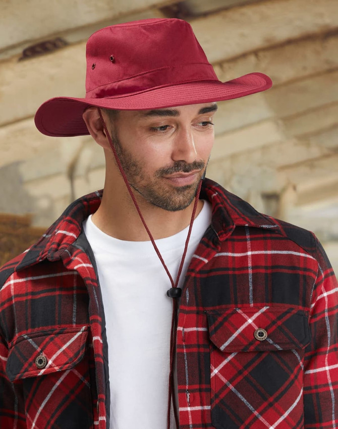 A maroon slouch hat featuring a break-away clip, paired with a red and black plaid jacket.