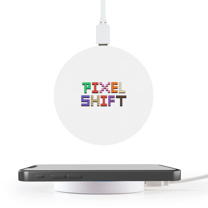 A round white wireless charger with a logo on top, positioned near a smartphone on a white surface.