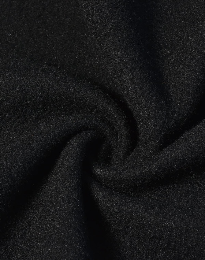 A close-up of black jacquard fleece fabric, showcasing its soft and textured surface.