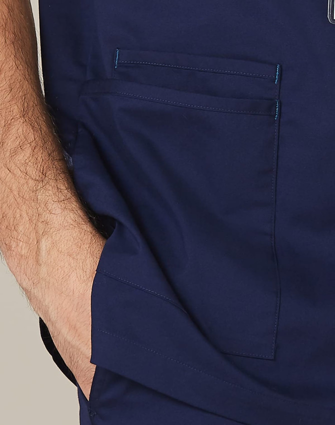 Men's scrub top in navy blue with contrast stitching and two front pockets. Features a logo on the fabric.