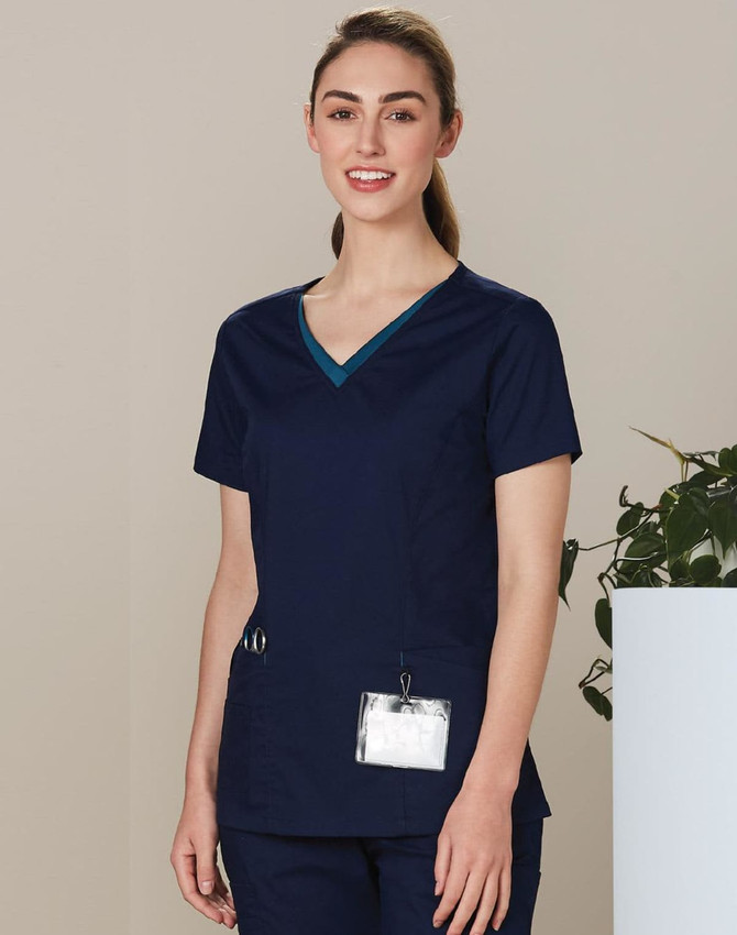 A navy short-sleeve scrub top with a contrast v-neckline and pockets, featuring a logo.