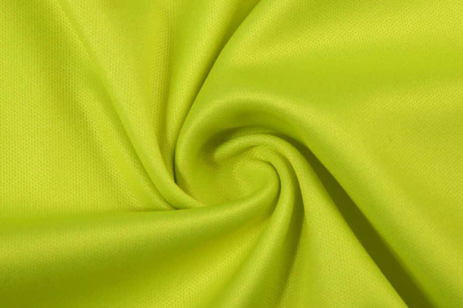 A bright yellow fabric, featuring a smooth and textured surface, arranged in a swirl pattern.