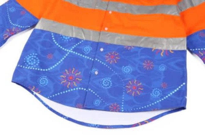 A vibrant blue and orange workshirt featuring reflective stripes and a colourful pattern. It has a logo on it.